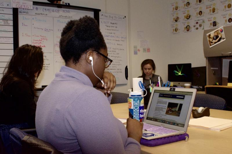 Three students work together at a desk