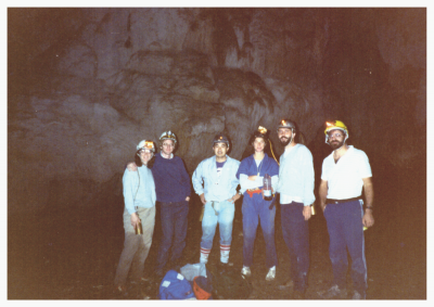 A group of scientists in a cave with headlamps on.