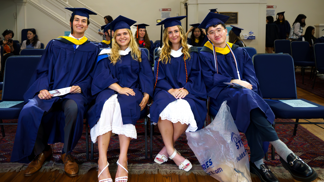 row of students in sitting in graduation regalia 