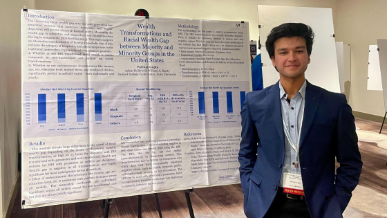 Parinay Gupta standing in front of research poster