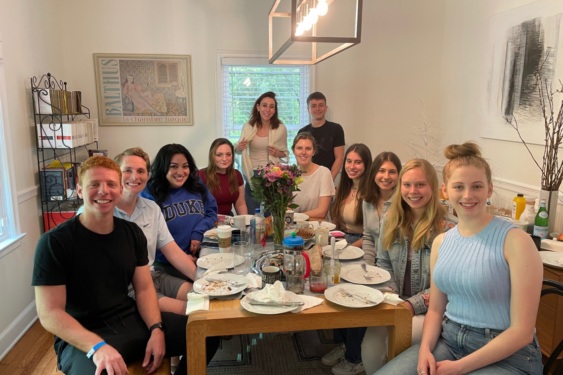 Students in French course gather around table for brunch