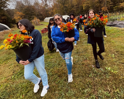 students carrying flowers to ofrenda