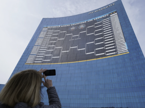 woman taking a photo of NCAA bracket on side of Marriott building