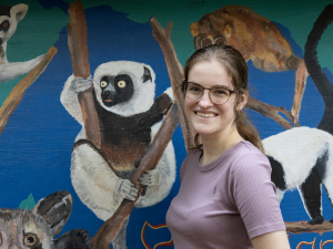 Caroline Shearer standing in front of lemur mural