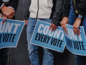 people holding signs that say "count every vote"