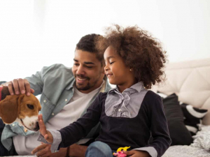 child with adult man and playing with a puppy