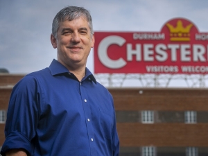 Chris Monroe posing in front of Chesterfield sign