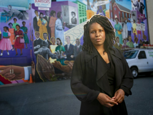 Candis Watts Smith standing in front of mural