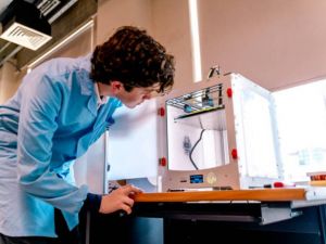 person looking at 3d printer 