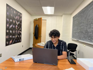 students sitting at desk typing on laptop