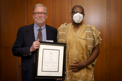 Two men standing with a framed award