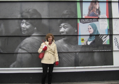 Helen Solterer standing against a wall with large photos in Belleville, France