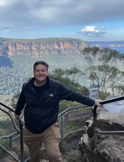 Tom Mehen in front of a scenic mountainscape