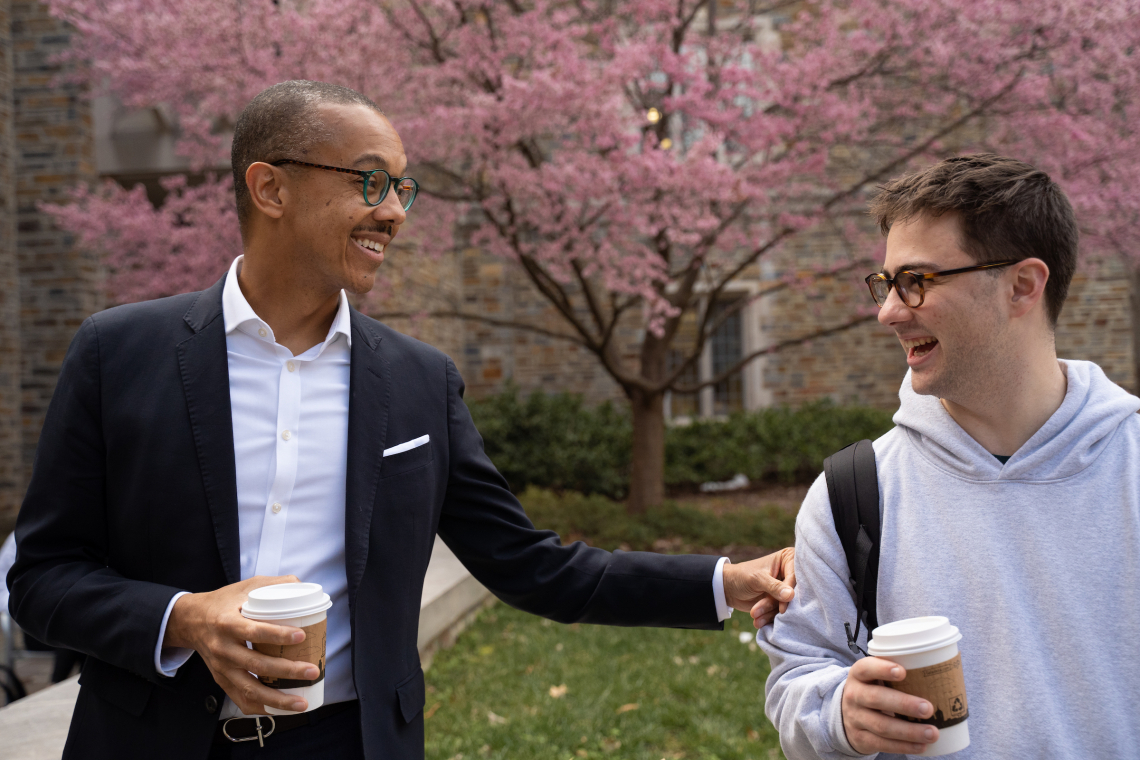 Bennett talks with students while walking with coffees