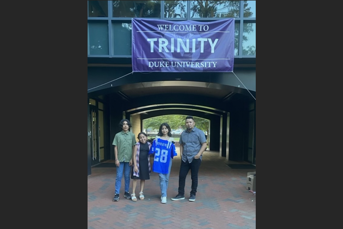 Amylyn holds up a Duke t-shirt on move-in day.